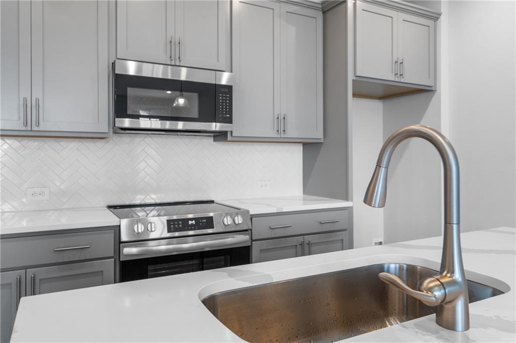 115 Pk Rdg Circle Cartersville, GA 30120 - Photo 11 of 30 a kitchen with stainless steel appliances granite countertop a sink a stove and a microwave