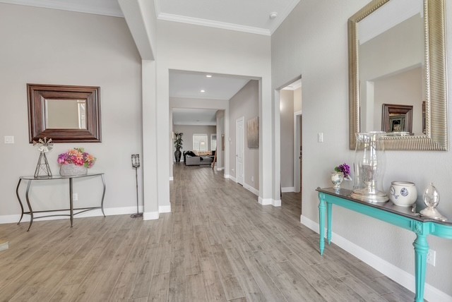 1541 North Blue Bonnet Lane Angleton, TX 77515 - Photo 4 of 28 a view of a hallway to a livingroom with wooden floor and furniture