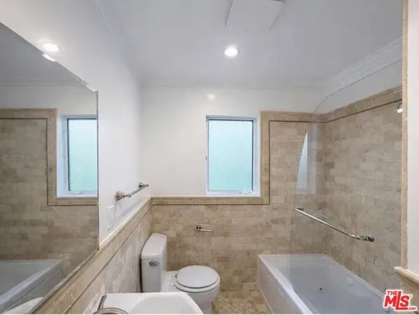 a bathroom with a granite countertop sink toilet and bathtub