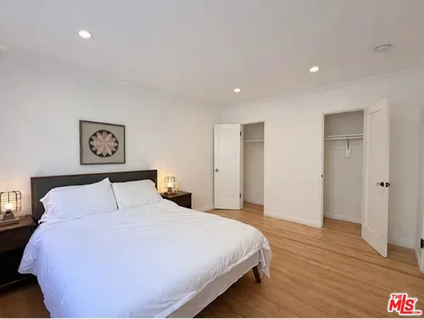 a bedroom with a bed and painting on the wall