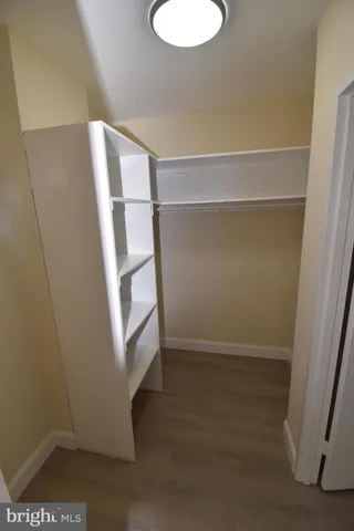 a view of walk in closet with empty racks