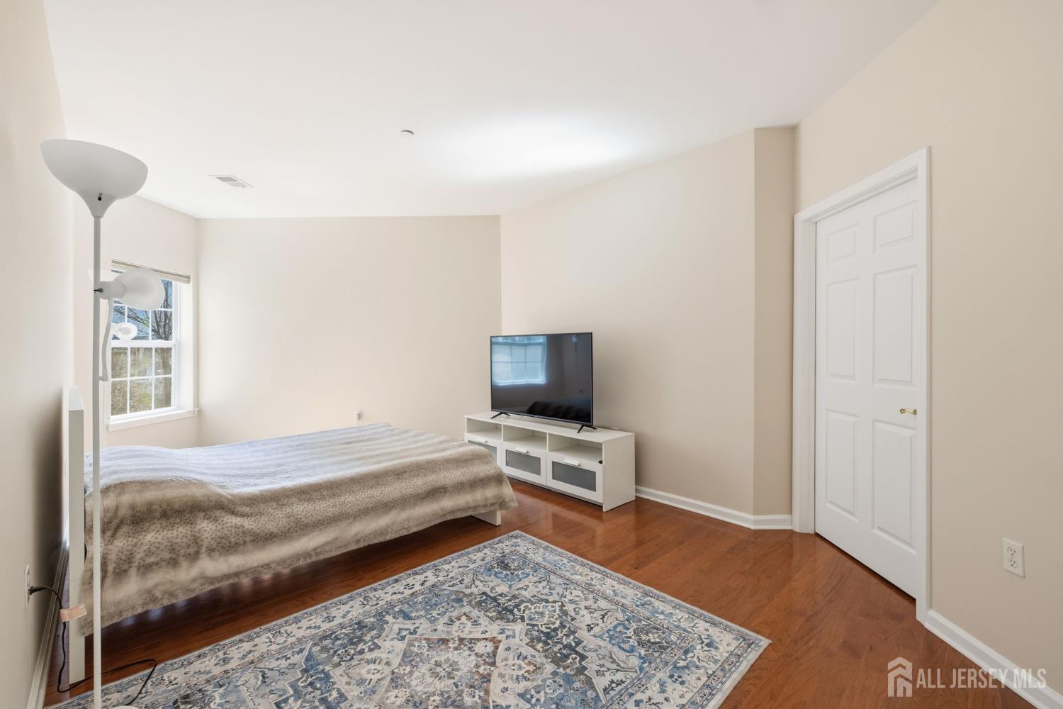 540 Cranbury Road, Unit 107 East Brunswick, NJ 08816 - Photo 9 of 20 a bedroom with a bed and wooden floor