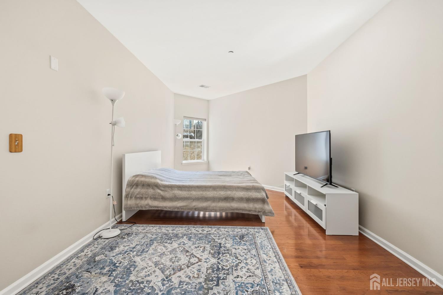 540 Cranbury Road, Unit 107 East Brunswick, NJ 08816 - Photo 10 of 20 a bedroom with a bed and flat screen tv