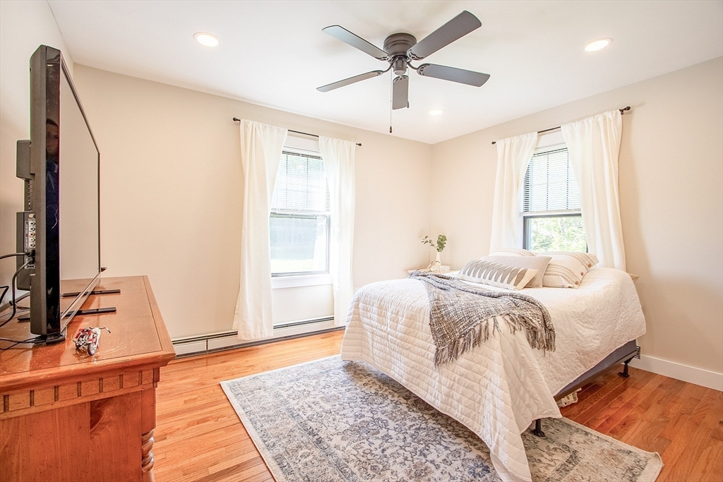 4287 South Athol Road Athol, MA 01331 - Photo 32 of 42 a bedroom with a large bed and a chandelier