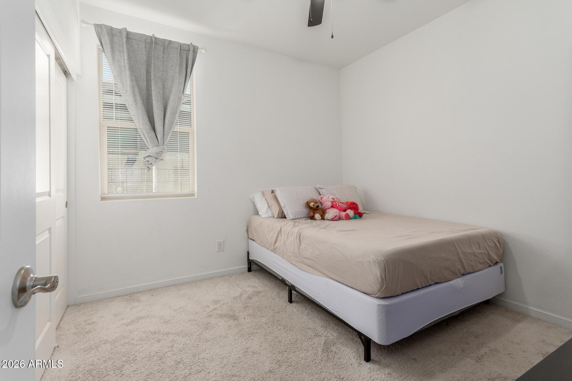 10734 West Bloch Road Tolleson, AZ 85353 - Photo 13 of 20 a white bed sitting in a bedroom next to a window