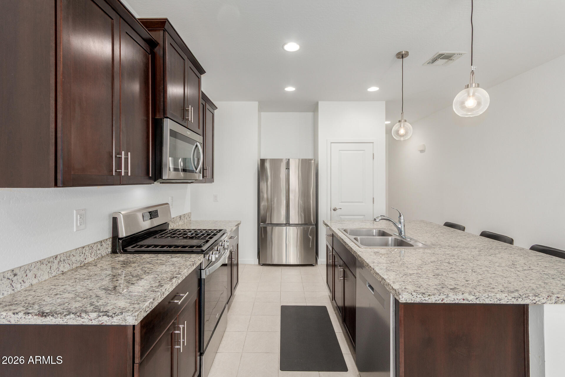 10734 West Bloch Road Tolleson, AZ 85353 - Photo 7 of 20 a kitchen with stainless steel appliances granite countertop a sink stove and refrigerator