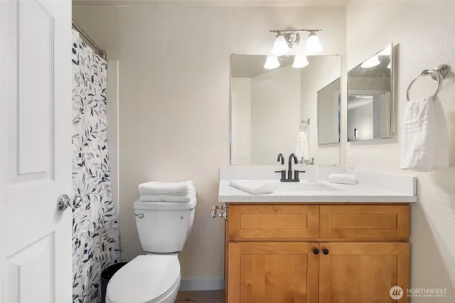 a bathroom with a granite countertop toilet sink and mirror