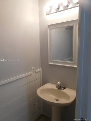 an empty room with a refrigerator and cabinet