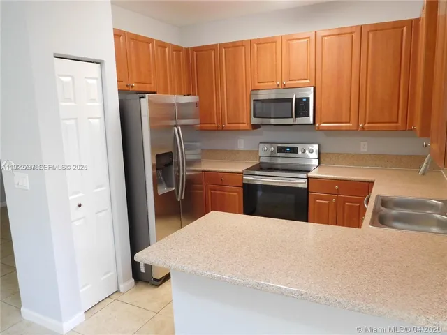 a kitchen with stainless steel appliances a stove a sink a microwave and cabinets