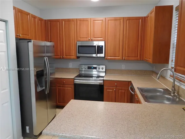 a kitchen with a refrigerator sink and microwave