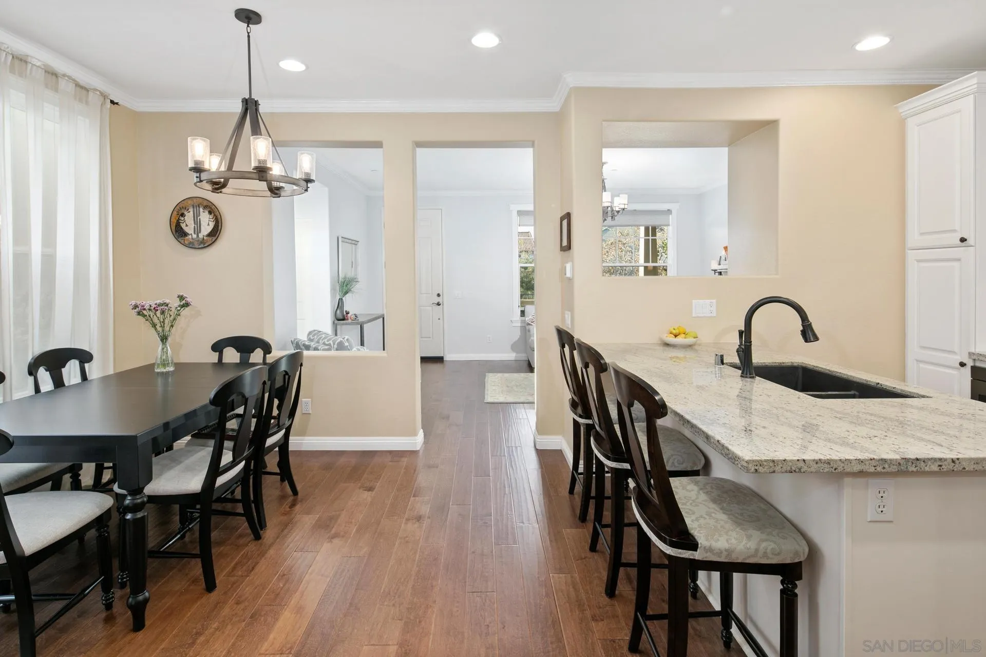 16633 Deer Ridge Road San Diego, CA 92127 - Photo 9 of 53 a dining room with wooden floor a chandelier a glass table and chairs
