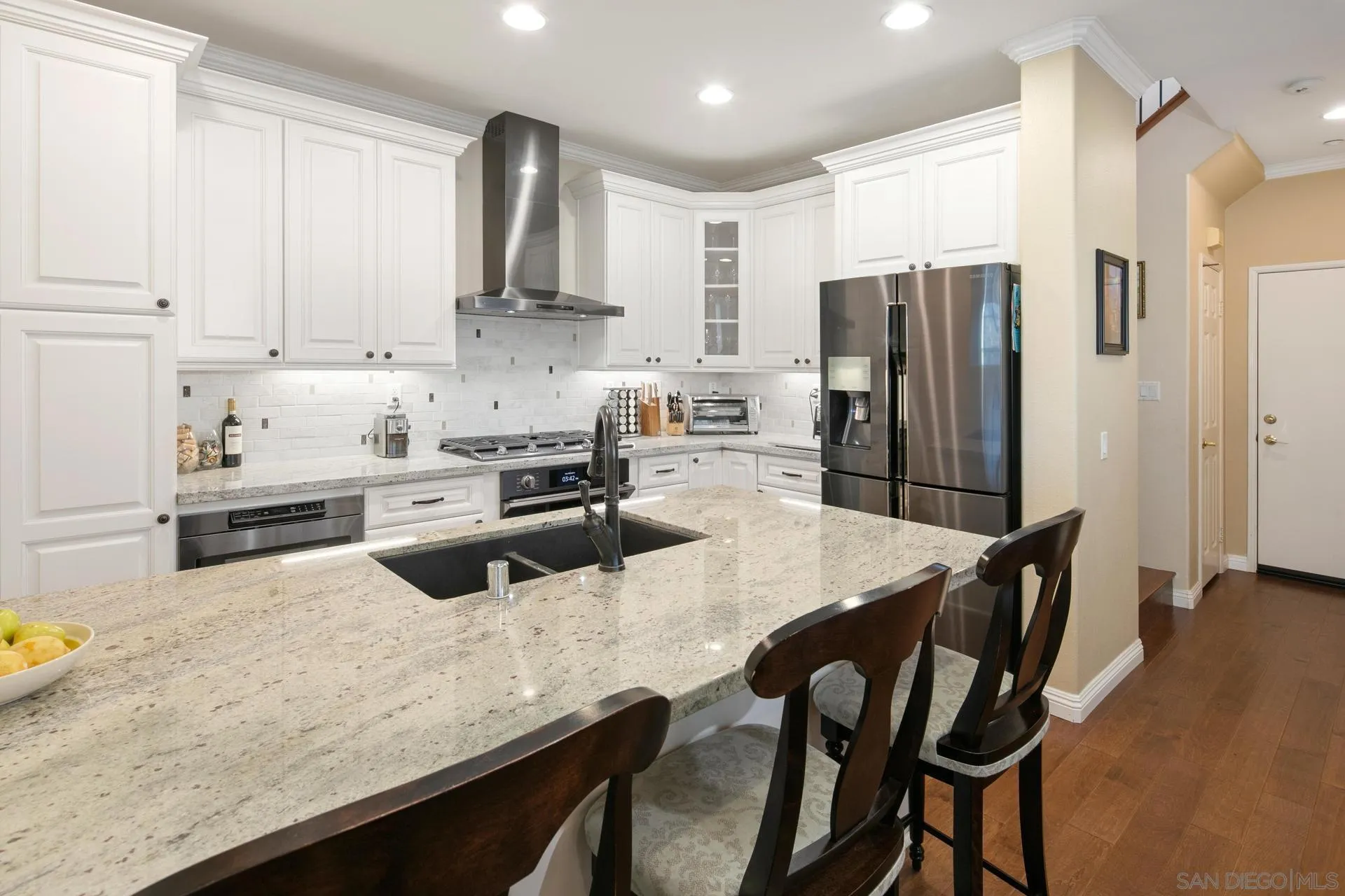 16633 Deer Ridge Road San Diego, CA 92127 - Photo 10 of 53 a kitchen with granite countertop a refrigerator a stove a sink a dining table and chairs