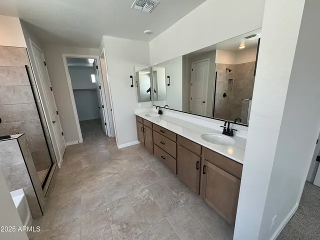 a spacious bathroom with double vanity and mirrors