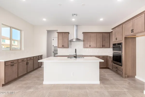 a kitchen with kitchen island a stove a sink a refrigerator and cabinets