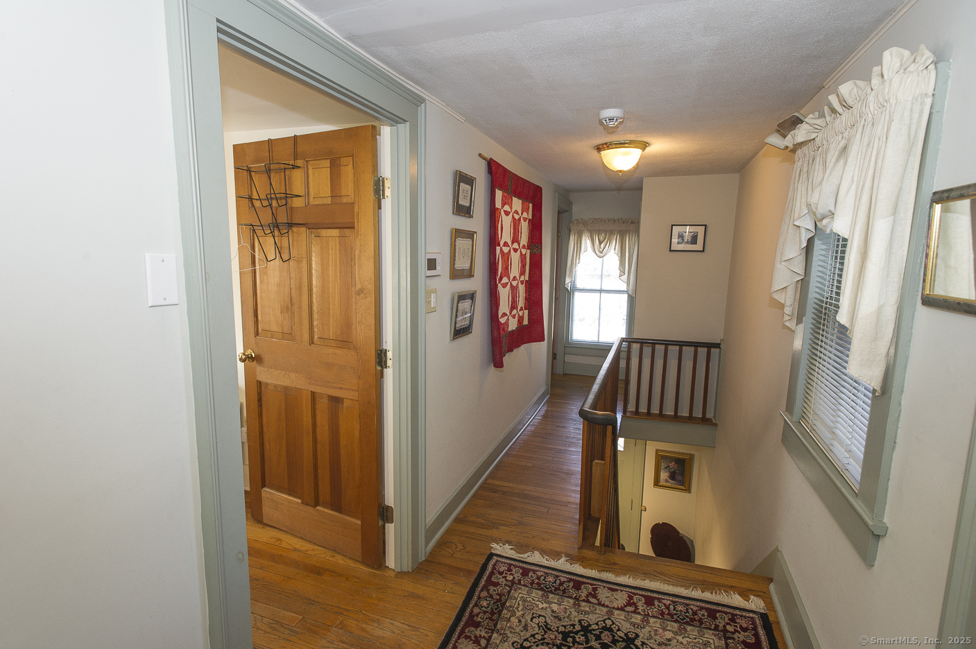 74 Park Lane Road New Milford, CT 06776 - Photo 12 of 22 a view of a hallway with wooden floor and staircase