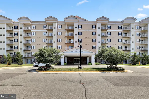 a front view of a building with a garden and plants