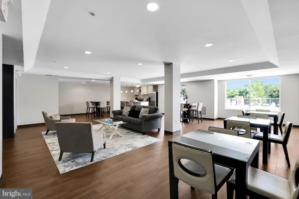 a living room with furniture a wooden floor and next to a window
