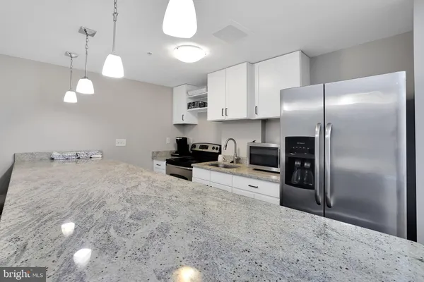 a kitchen with stainless steel appliances a refrigerator sink and microwave