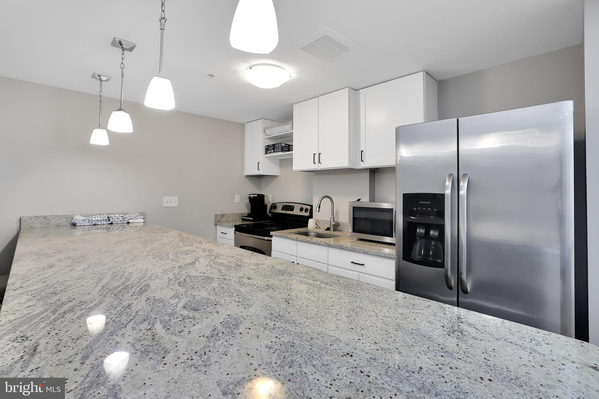 6301 Edsall Road, Unit 104 Alexandria, VA 22312 - Photo 23 of 28 a kitchen with stainless steel appliances a refrigerator sink and microwave