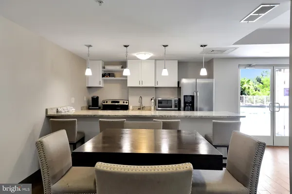 a large kitchen with kitchen island a dining table chairs and a window