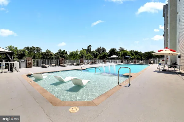 a view of a swimming pool with a bench and some trees