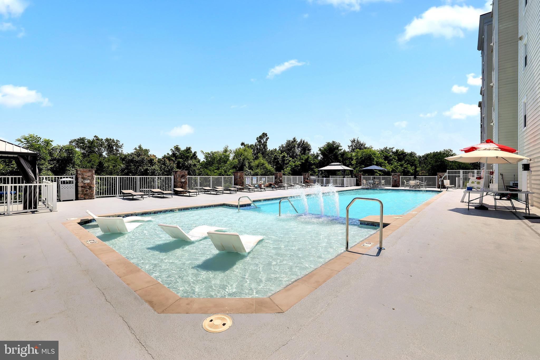 6301 Edsall Road, Unit 104 Alexandria, VA 22312 - Photo 26 of 28 a view of a swimming pool with a bench and some trees
