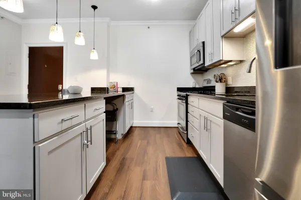 a kitchen with granite countertop a sink a counter space appliances and cabinets