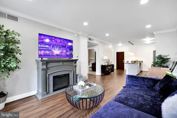 a living room with furniture a fireplace and a potted plant