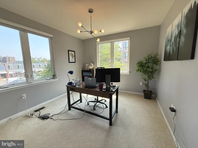 a view of a livingroom with workspace and a window