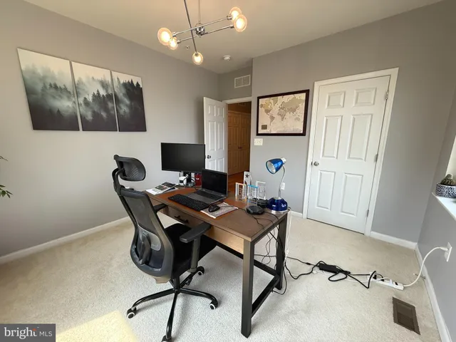 a view of a workspace with furniture and a potted plant