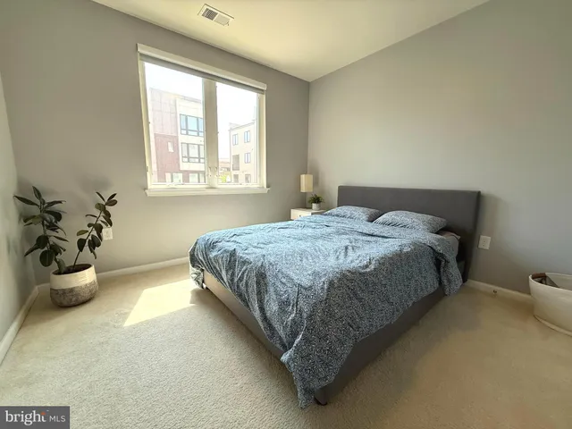 a bedroom with a bed and a potted plant
