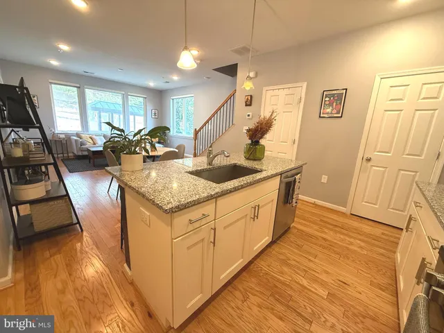 a view of a kitchen counter top space with furniture and wooden floor