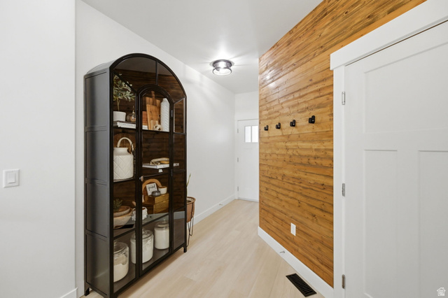 57 McCall Ln. Farmington, UT 84025 - Photo 4 of 36 Entryway featuring a wood-panel accent wall with black wall hooks