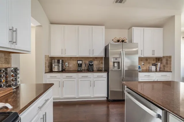 a kitchen with granite countertop a refrigerator and a sink