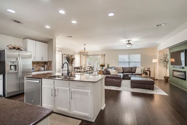 a kitchen with kitchen island white cabinets and stainless steel appliances