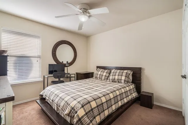 a bedroom with a bed a dresser and a large mirror