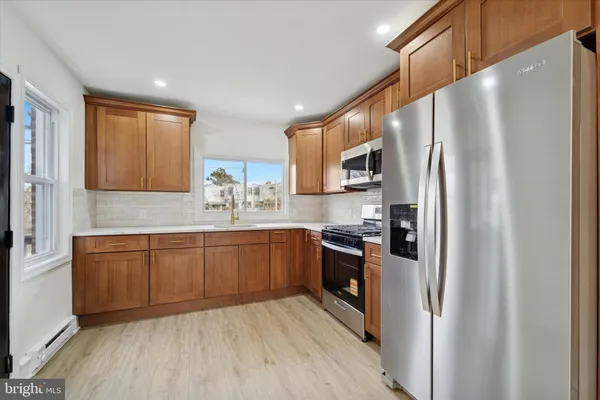 a kitchen with stainless steel appliances granite countertop a refrigerator sink and microwave