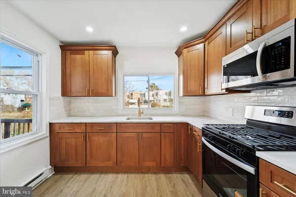 a kitchen with stainless steel appliances a sink cabinets and a stove top oven