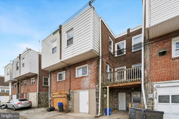 a front view of a building with lot of cars and trees