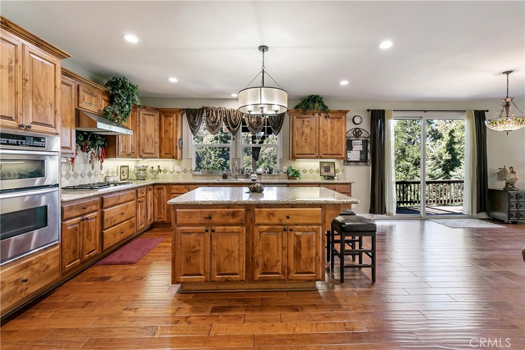 28449 Fresh Spring Lane Lake Arrowhead, CA 92352 - Photo 1 of 55 a kitchen with stainless steel appliances granite countertop a stove top oven a sink dishwasher and a dining table with wooden floor