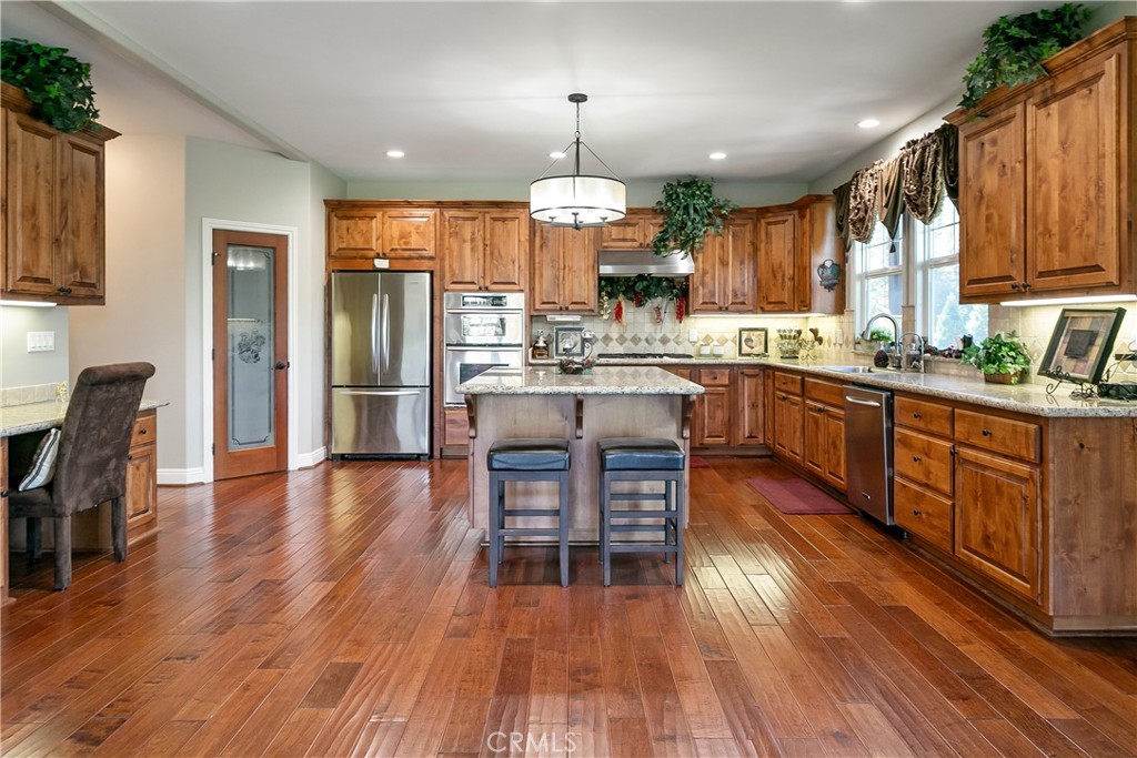 28449 Fresh Spring Lane Lake Arrowhead, CA 92352 - Photo 13 of 55 a kitchen with stainless steel appliances granite countertop hardwood floor sink stove dining table and chairs