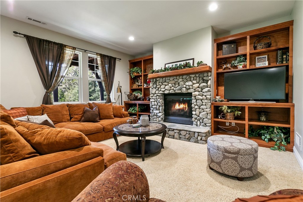 28449 Fresh Spring Lane Lake Arrowhead, CA 92352 - Photo 19 of 55 a living room with furniture a flat screen tv and a fireplace