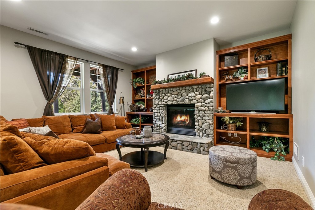 28449 Fresh Spring Lane Lake Arrowhead, CA 92352 - Photo 20 of 55 a living room with furniture a flat screen tv and a fireplace