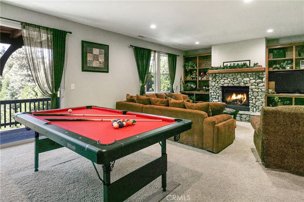 28449 Fresh Spring Lane Lake Arrowhead, CA 92352 - Photo 23 of 55 a living room with a table chairs and a fireplace