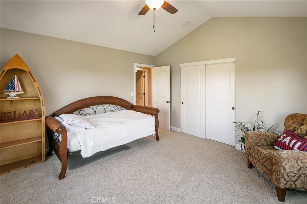 28449 Fresh Spring Lane Lake Arrowhead, CA 92352 - Photo 37 of 55 a spacious bedroom with a bed and a chandelier