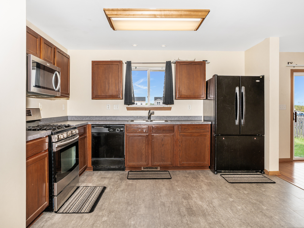 816 Kennedy Street Waterman, IL 60556 - Photo 11 of 27 a kitchen with stainless steel appliances granite countertop a refrigerator stove and sink