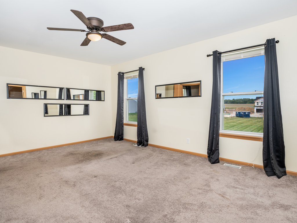 816 Kennedy Street Waterman, IL 60556 - Photo 14 of 27 a view of a big room with closet area and a ceiling fan
