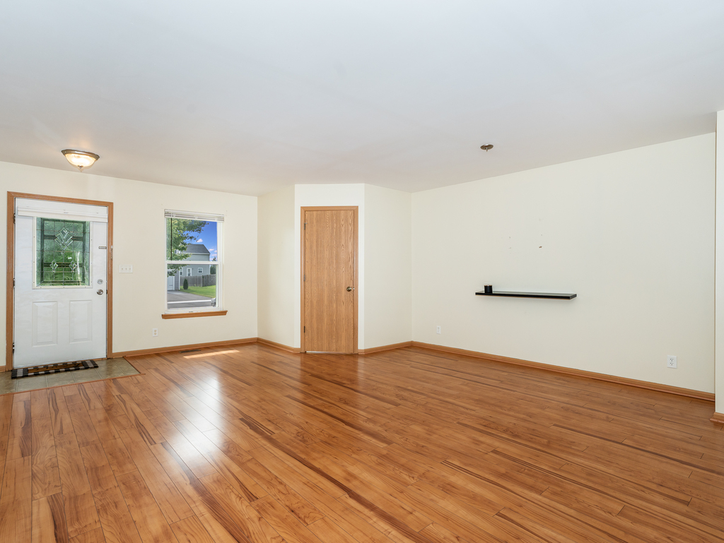 816 Kennedy Street Waterman, IL 60556 - Photo 4 of 27 an empty room with wooden floor and windows