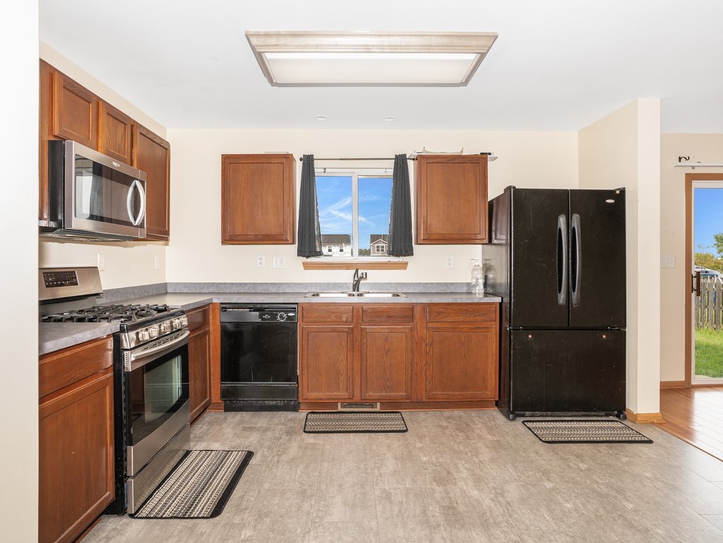 816 Kennedy Street Waterman, IL 60556 - Photo 10 of 27 a kitchen with stainless steel appliances granite countertop a refrigerator stove and sink
