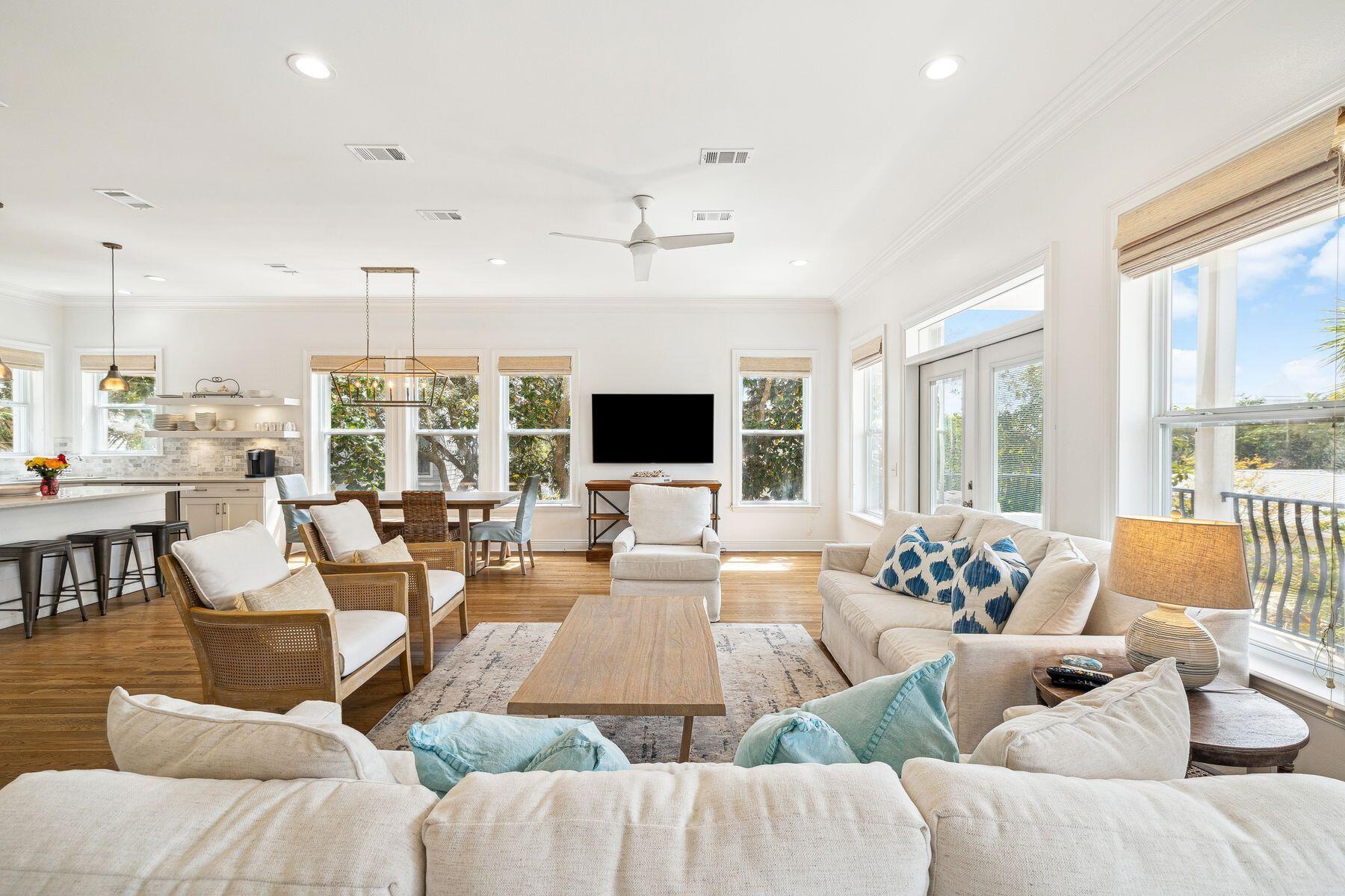 a living room with furniture flat screen tv and a large window
